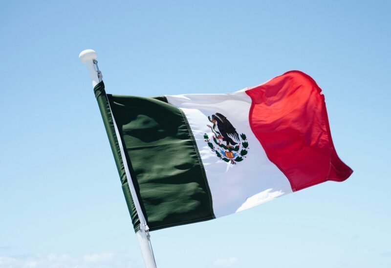 Drapeau mexicain flottant dans le ciel bleu.