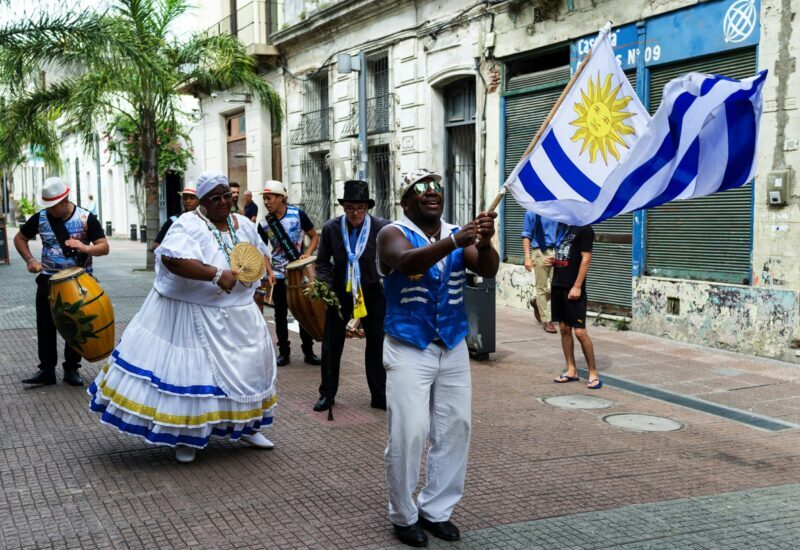 Groupe défilant avec le drapeau uruguayen dans la rue.