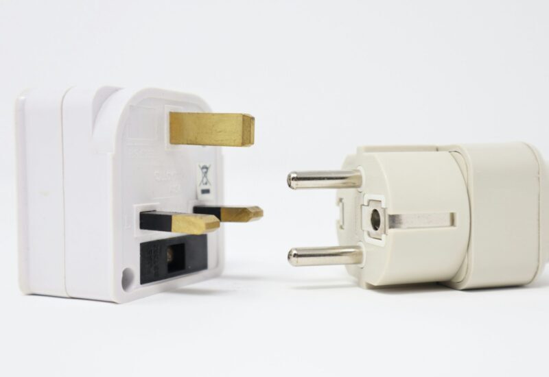 Adaptador con tres patas rectangulares junto a otro con dos patas redondas