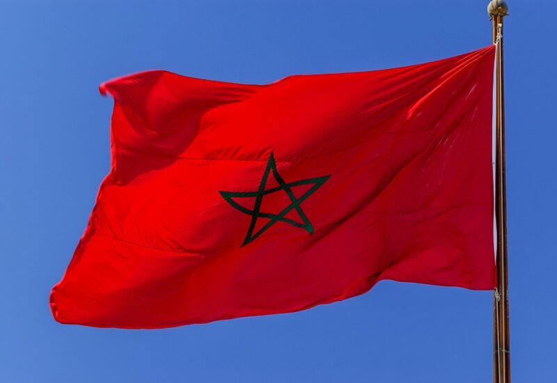 Bandera de Marruecos ondeando en su mástil bajo un cielo azul